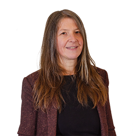 Photo d'une femme avec des cheveux bruns longs qui sourit et qui porte une blazer marron.